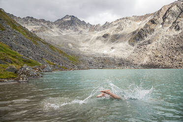 Mann taucht zum Schwimmen in den Upper Reed Lake, Talkeetna Mountains, Alaska - CAVF86648