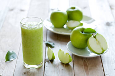 Nahaufnahme eines Getränks mit Granny Smith Äpfeln auf einem Holztisch - EYF09076