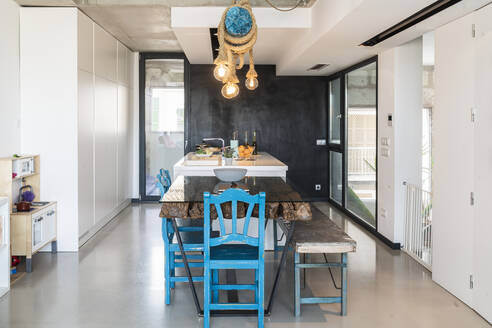 Illuminated lights hanging over dining table in modern kitchen at home - JAF00033