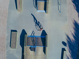 Man cycling in skate park, aerial view - KNTF04774