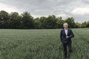 Älterer Geschäftsmann auf einem Feld auf dem Lande - GUSF04059