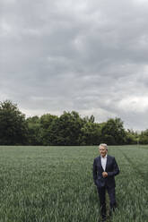 Älterer Geschäftsmann auf einem Feld auf dem Lande - GUSF04060