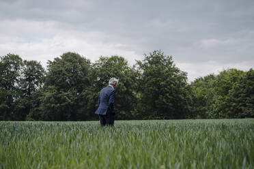 Senior businessman on a field in the countryside - GUSF04152