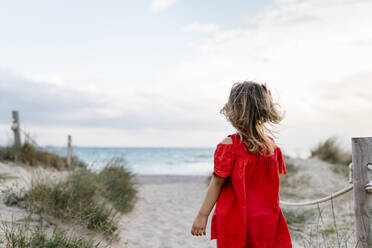 Mädchen spaziert am Strand gegen bewölkten Himmel - EGAF00381