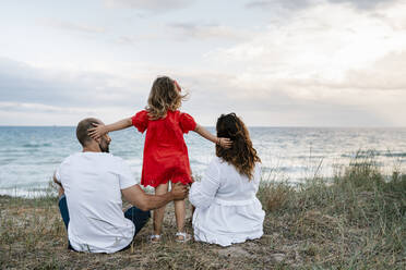 Family spending quality time at beach against cloudy sky - EGAF00382