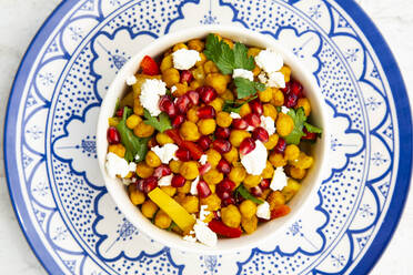 Schüssel mit vegetarischem Salat mit Kichererbsen, Kurkuma, Paprika, Tomaten, Petersilie, Feta-Käse und Granatapfelkernen - LVF08966
