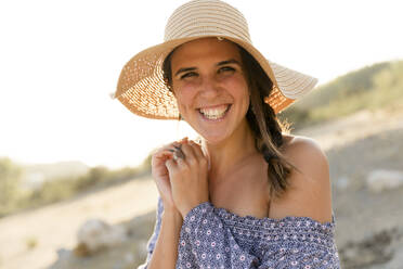 Happy young woman wearing sun hat during sunny day - LVVF00155