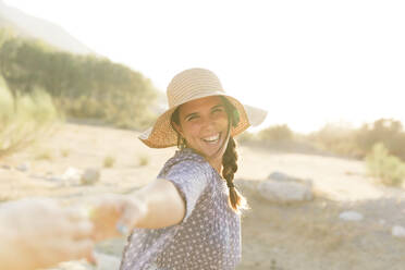 Fröhliche junge Frau mit Sonnenhut an einem sonnigen Tag - LVVF00156