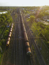 Russia, Leningrad Oblast, Tikhvin, Aerial view of stationary railroad cars at dusk - KNTF04804