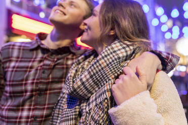 Nahaufnahme eines jungen Paares, das nachts in der Stadt Weihnachten genießt - WPEF03121