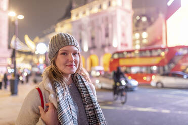 Junge Frau in warmer Kleidung auf dem Piccadilly Circus bei Nacht - WPEF03127