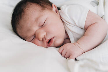 Close-up cute newborn baby girl sleeping on bed in hospital - GEMF03914