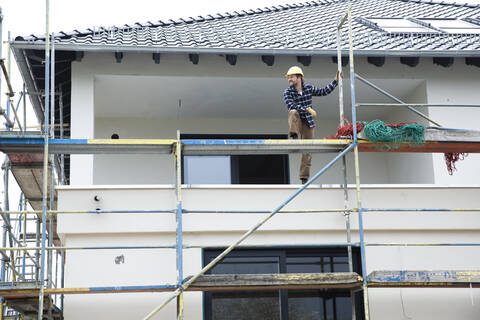Bauarbeiter auf einem Baugerüst auf einer Baustelle, lizenzfreies Stockfoto