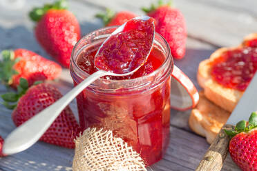 Nahaufnahme von Erdbeeren und Marmelade im Glas auf dem Tisch - EYF09231