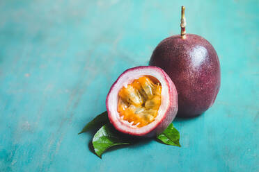 High Angle View of Passionsfrucht und Blatt auf dem Tisch - EYF09347