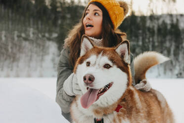 Frau mit Schlittenhund im Winter - EYF09455