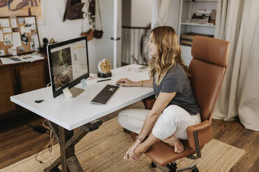 Frau mit Computer auf dem Schreibtisch zu Hause - SMSF00007