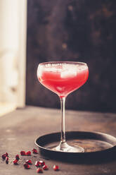 Glass of pomegranate fizz with pomegranate juice, ice cubes and tonic water - SBDF04289