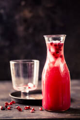 Carafe of pomegranate fizz with pomegranate juice, ice cubes and tonic water - SBDF04291