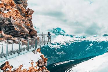 Frau schaut auf schneebedeckte Berge gegen den Himmel - EYF09502