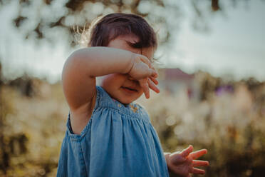 Baby Girl Covering Face While Standing Outdoors - EYF09514