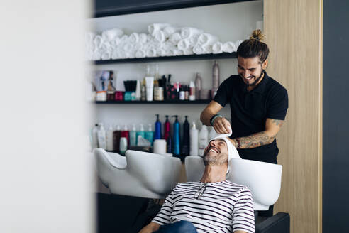 Hairdresser wrapped towel on client's hair at salon - SODF00812