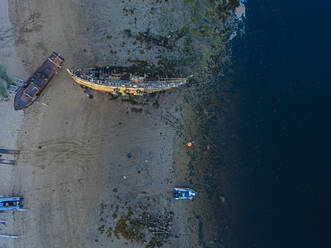 Luftaufnahme alter verlassener Boote am Küstenstrand der Barentssee - KNTF04835