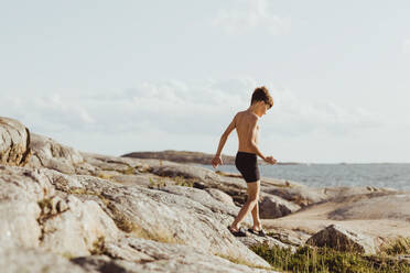 Shirtless boy walking on archipelago during weekend - MASF18457