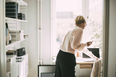 Frau im Büro zu Hause am Telefon - MASF18529