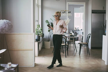 Woman working at home on the phone having a conversation - MASF18537