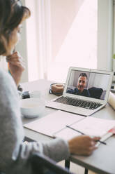 Coworkers having an online meeting at home - MASF18563