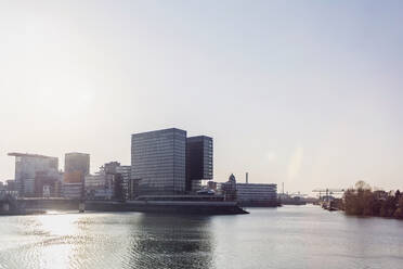 Deutschland, Nordrhein-Westfalen, Düsseldorf, Sonnenschein über Medienhafen mit Stadttor im Hintergrund - MMAF01343