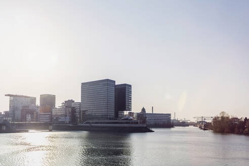 Deutschland, Nordrhein-Westfalen, Düsseldorf, Sonnenschein über Medienhafen mit Stadttor im Hintergrund - MMAF01343