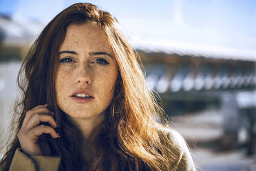 Confident woman with freckles on face during sunny day - EHF00379