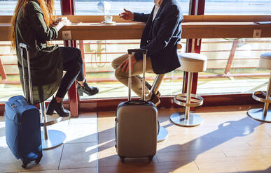 Geschäftspaar sitzt mit Gepäck im Flughafencafé - EHF00390