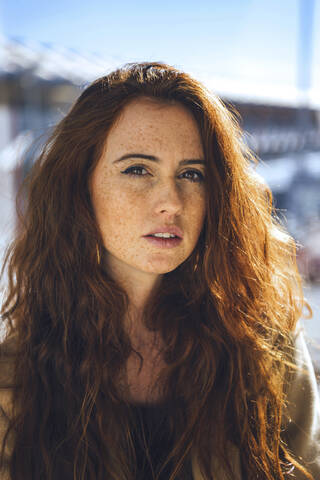 Confident woman with freckles on face during sunny day stock photo