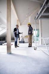Architekt und Bauarbeiter planen im Stehen beim Bau eines Hauses - MJFKF00436