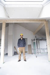 Construction worker standing in house under construction - MJFKF00438
