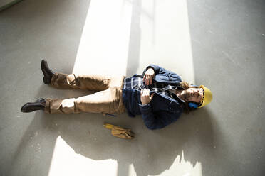 Auf dem Boden schlafender Bauarbeiter bei der Renovierung eines Hauses - MJFKF00468