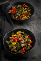 Two bowls of stir-fried vegan salad with eggplants, paprika and parsley - LVF08980