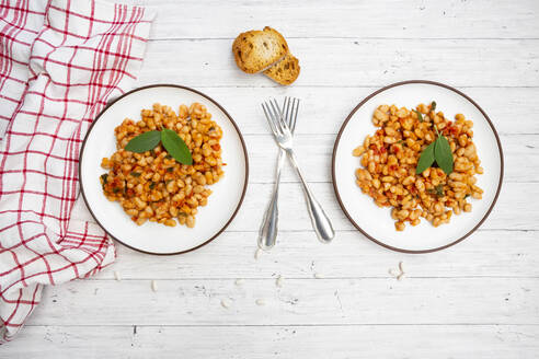 Zwei Teller italienische gebackene Bohnen (fagioli alluccelletto) mit Tomaten und Salbei - LVF08983