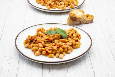 Plate of Italian baked beans (fagioli alluccelletto) with tomatoes and sage - LVF08984