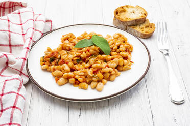 Plate of Italian baked beans (fagioli alluccelletto) with tomatoes and sage - LVF08986