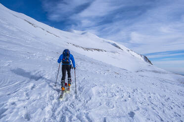 Man cross-country skiing on Sibillini mountain against sky, Umbrian, Italy - LOMF01179