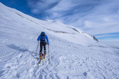 Mann beim Skilanglauf auf dem Berg Sibillini gegen den Himmel, Umbrien, Italien - LOMF01179