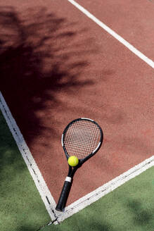 Tennisball mit Schläger auf dem Boden eines Sportplatzes - EGAF00420