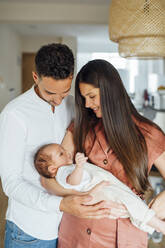 Loving parents carrying baby boy at home - OCMF01455