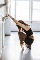 Ballerina bei Dehnungsübungen im Studio - DAWF01725