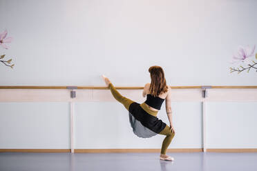 Ballerina streckt das Bein im Tanzstudio - DAWF01727