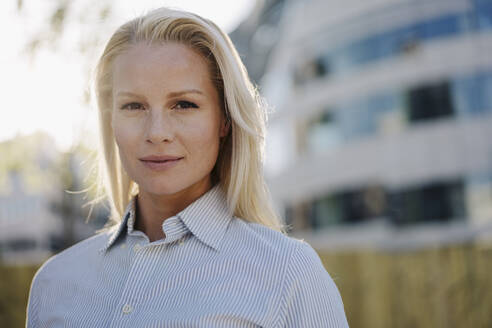 Close-up of beautiful blond female professional at financial district in city - JOSEF01024